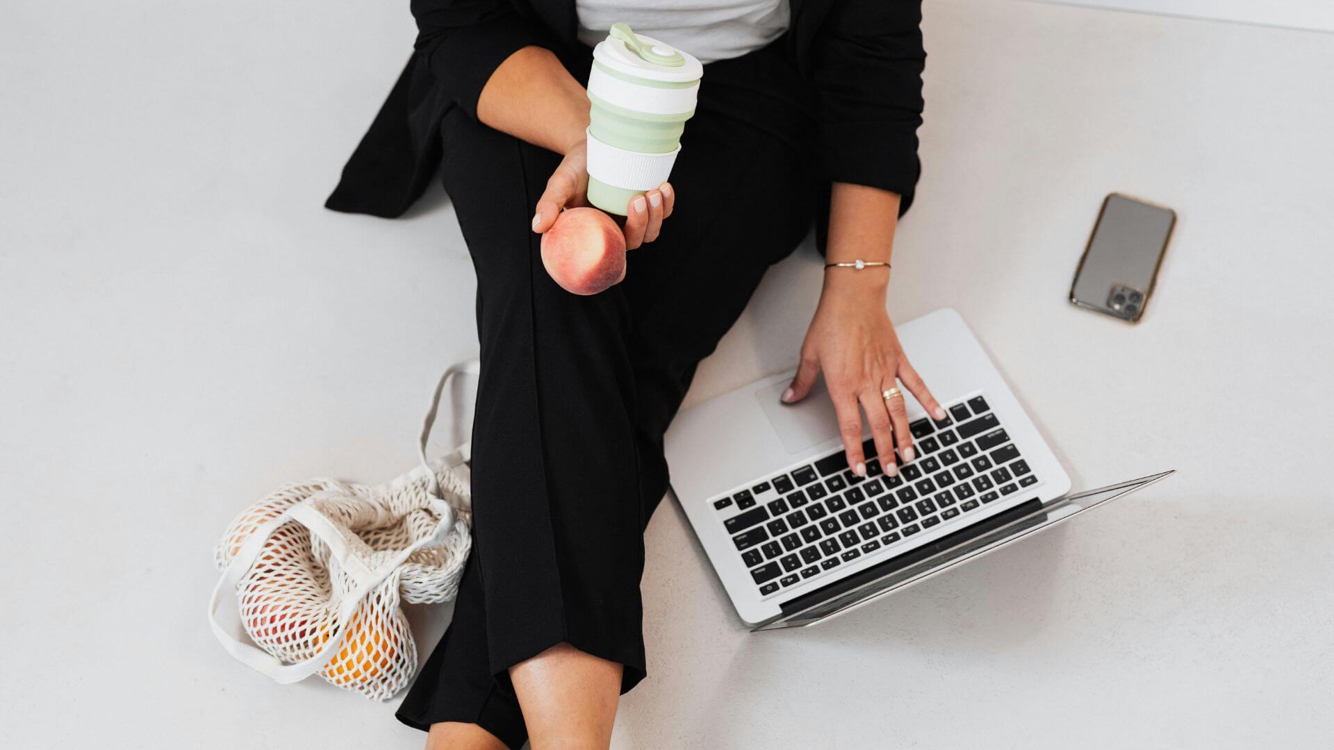 Mujer emprendedora disfrutando libertad empresarial mientras aprende neurogestión con su portátil y café en mano – Curso Libertad Empresarial 360° de CHISPA DETONANTE